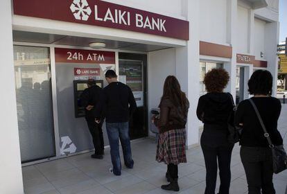 Clientes del Laiki Bank de Larnaca (Chipre) hacen cola en el cajero autom&aacute;tico, ayer s&aacute;bado por la ma&ntilde;ana