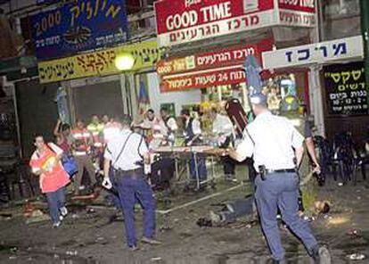 Policías y miembros de los servicios de socorro, en el lugar del atentado suicida, anoche en Tel Aviv.