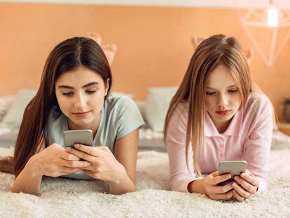 Dos chicas utilizan sus tel&eacute;fonos m&oacute;viles. 