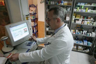 Un farmacéutico andaluz consulta una receta electrónica.