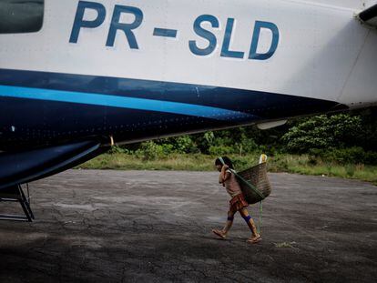 Un niño indígena camina cerca de un avión usado por personal del gobierno brasiñero en Roraima, el 10 de enero 2024.