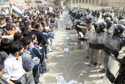 Agentes antidisturbios iraquíes bloquean el paso a un grupo de manifestantes en la plaza de la Liberación de Bagdad.