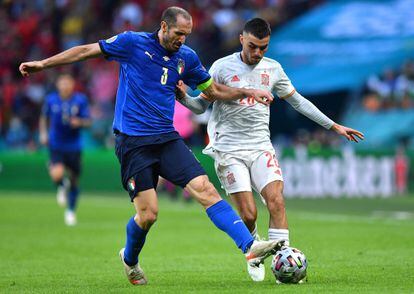 El defensa italiano Giorgio Chiellini (I)  disputa el balón con el mediocentro español Pedri (D) en las semifinales de la Eurocopa