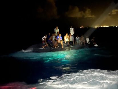 Sobrevivientes de un bote volcado cerca de la isla Nueva Providencia (Bahamas), en una fotografía cedida por las fuerzas armadas de las Bahamas, este domingo 24 de julio.