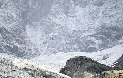 Un helicóptero vuela sobre un segmento del glaciar Planpincieux en el lado italiano del área del macizo del Mont Blanc, el 25 de septiembre de 2019. El glaciar, situado en el Valle de Aosta, al noroeste de Italia, se está derritiendo a una velocidad acelerada entre agosto y septiembre y amenaza con derrumbarse en un valle paralelo al de la famosa localidad alpina de Courmayeur, una zona muy poco poblada, según las autoridades locales.