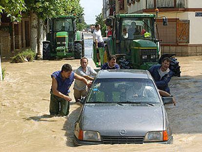 Un grupo de vecinos de Cortes (Navarra) retiran un vehículo en una de las calles inundadas por la tromba de lluvia.