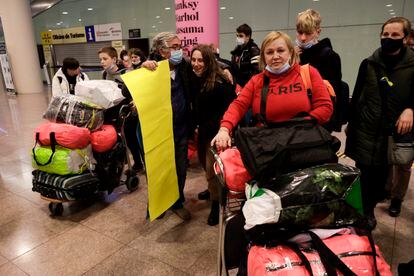 Una grupo de pasajeros ucranios, con su equipaje, en la terminal del aeropuerto de El Prat. / QUIQUE GARCÍA (EFE)