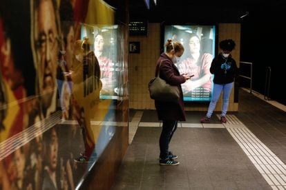 Dos mujeres miran el móvil en el metro de Barcelona.