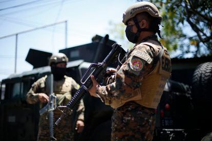 Soldados prestan guardia en un punto de control, en San Salvador.