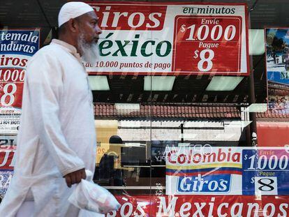 Un hombre camina delante de una tienda especializada en viajes y env&iacute;o de dinero a Latinoam&eacute;rica.