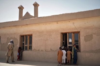 Varios niños se asoman al interior de la mezquita en la que predicaba el fundador de los talibanes, el mulá Omar