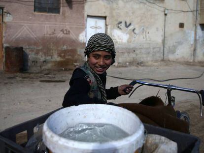 Un ni&ntilde;o transporta el agua en una barrio de Damasco, este febrero.
 