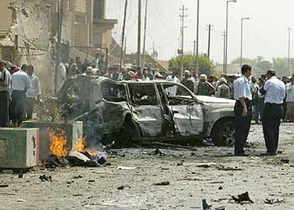Policías iraquíes y militares de EE UU inspeccionan la zona del atentado.