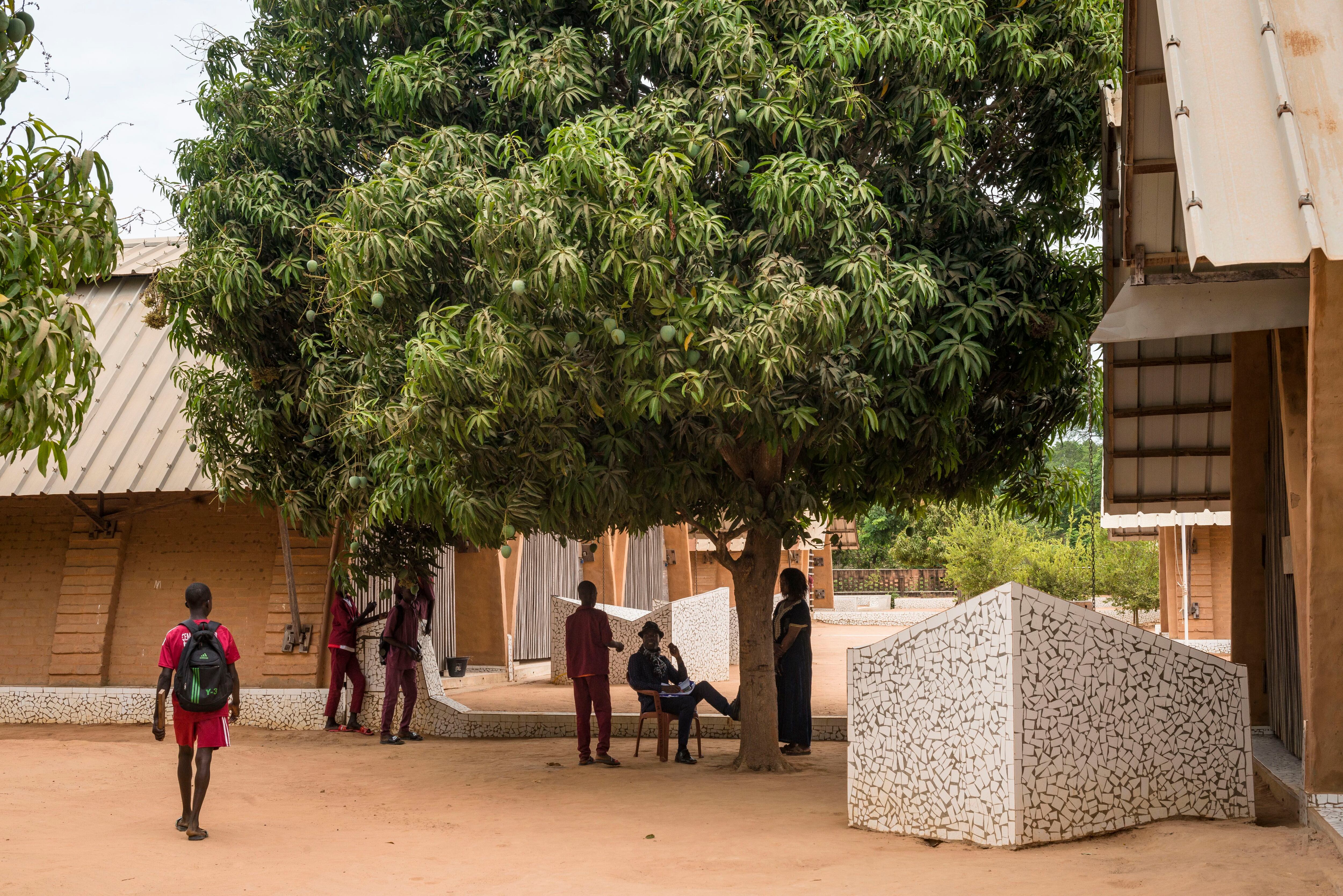 Esta escuela pública, que recibió el premio Aga Khan de arquitectura en 2022, es un modelo de arquitectura sostenible y adaptado a su entorno. En la imagen, un árbol de mango integrado en el complejo.