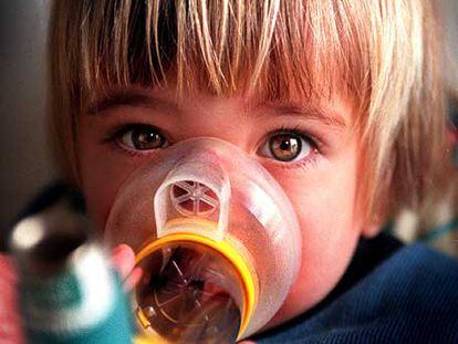 Una niña con asma se medica con inhaladores.