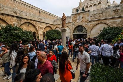 Salida de la misa en la Basílica de la Natividad de Belén. Tras más de veinte años nadie repara enel disparo en la espalda de la estatua de San Jerónimo, recuerdo de la Segunda Intifada, que preside la entrada de la Basílica.