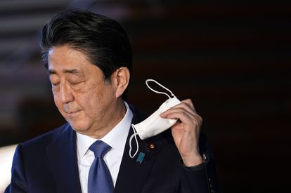 Shinzo Abe, primer ministro japonés, se quita la mascarilla al llegar a la rueda de prensa para anunciar que declarará el estado de alerta sanitaria