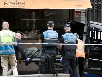 Sanitarios y policías trasladan el cadáver de una mujer asesinada en Pamplona por su pareja el sábado.