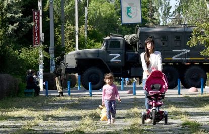 Una mujer y una niña caminaban por un parque mientras patrullaban soldados rusos, el 20 de mayo en Skadovsk, en la provincia de Jersón.