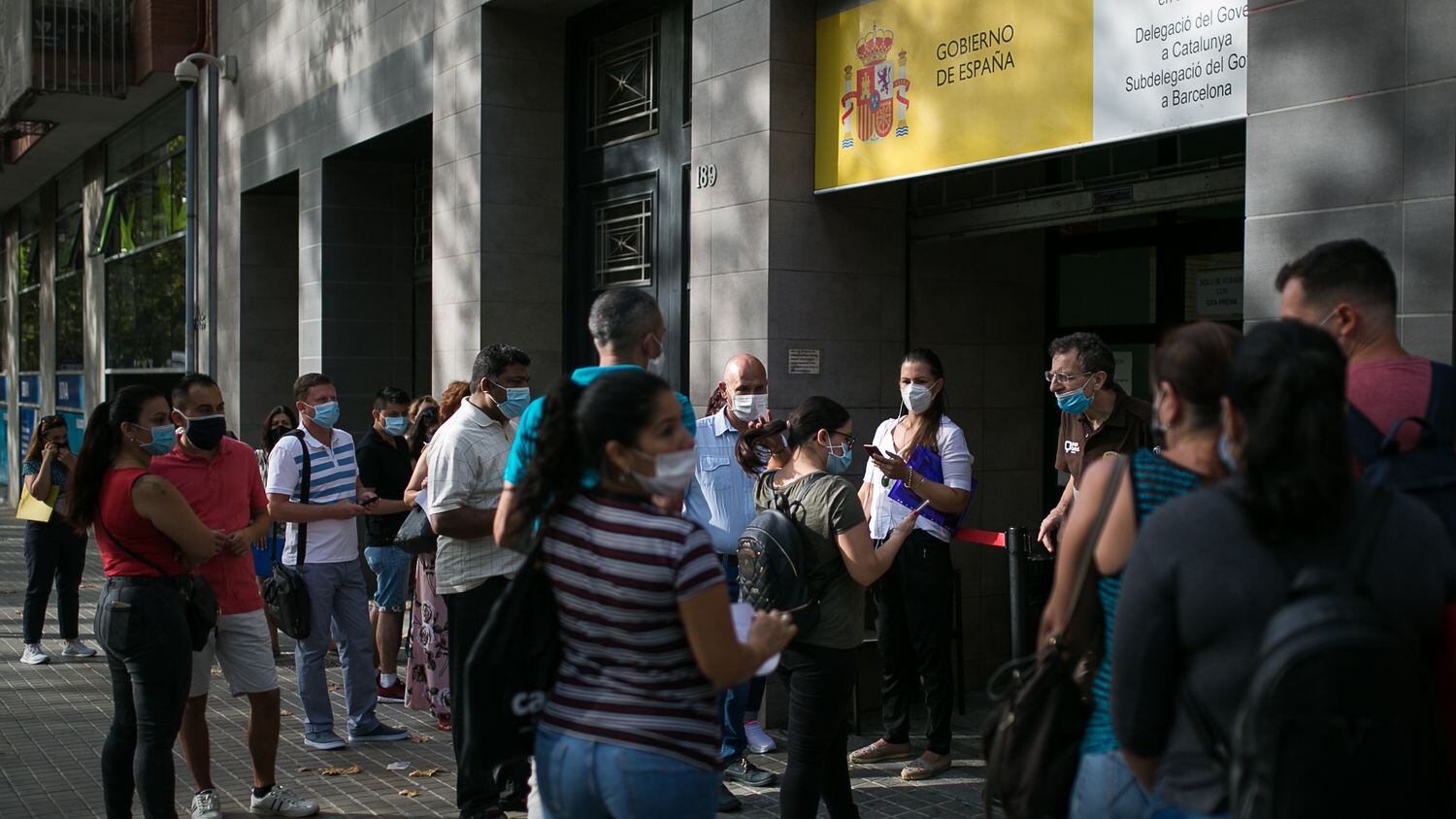 Cola de personas en las puertas de la oficina de Extranjería, en Barcelona.