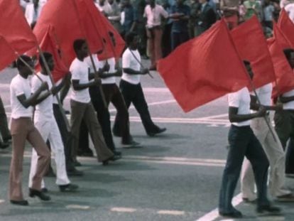 Desfile de civiles en África con banderas comunistas.