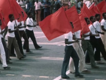 Desfile de civiles en África con banderas comunistas.