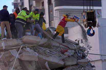 Miembros de los equipos de rescate trabajan entre los escombros de un edificio hundido en la ciudad de Adana (Turquía). 