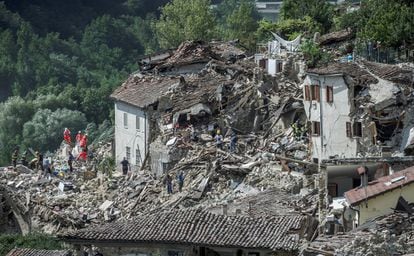 Equipos de emergencia buscan supervivientes entre los escombros causados por un terremoto en Pescara del Tronto (Italia).