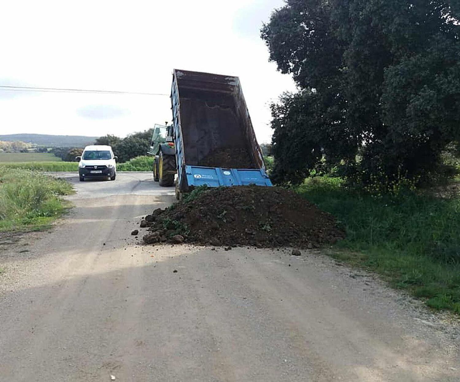 Un camión vuelca arena para cerrar uno de los accesos de Setenil de las Bodegas.