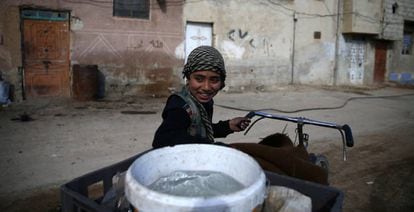 Un ni&ntilde;o transporta el agua en una barrio de Damasco, este febrero.
 