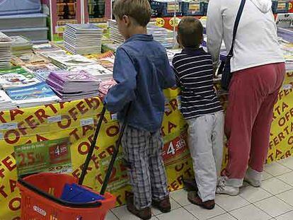 Una familia mira libros de texto en una superficie comercial.