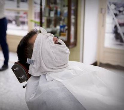 Afeitado con paños calientes en la barbería Moderna, en Madrid.