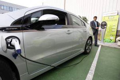 Un hombre se prepara para cargar la batería de un vehículo eléctrico. EFE/Archivo