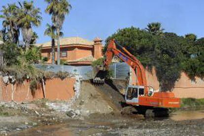 Una excavadora durante las labores de derribo del muro del chalé del actor Antonio Banderas en Marbella, que acomete el Ayuntamiento de la ciudad, y cuyas obras finalizarán en un mes. Las obras se desarrollan en virtud de la cesión de suelo con la que el artista debe compensar al municipio por la situación irregular de la vivienda.