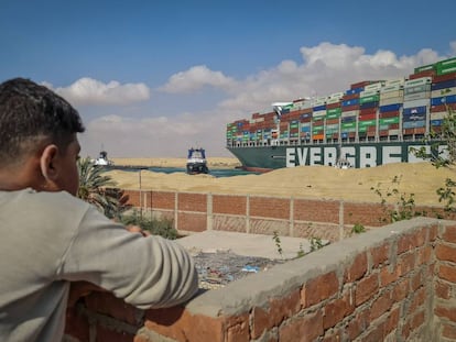 Un niño observa los trabajos de rescate en el canal de Suez.