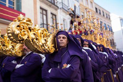 Hombres de trono (que cargan las imágenes religiosas sosteniendo varales con el hombro) portan a Nuestro Padre Jesús Nazareno de los Pasos en el Monte Calvario durante el recorrido procesional en Málaga, el 16 de abril de 2019.