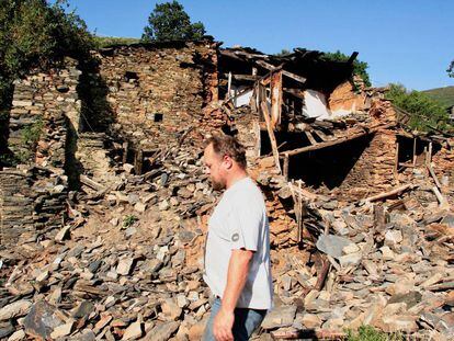 Martin Verfondern, en septiembre de 2009, pasa ante una de las ruinas que siembran el pueblo de Santoalla do Monte.