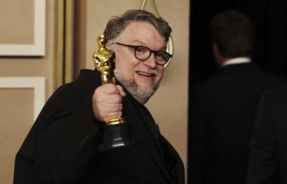 Guillermo del Toro sostiene y muestra la estatuilla del Oscar.