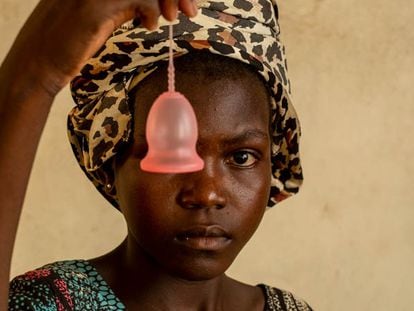 Una niña posa con una copa menstrual, un producto que puede ayudar a las adolescentes de países con problemas de agua a conseguir mejor higiene durante los días de regla.