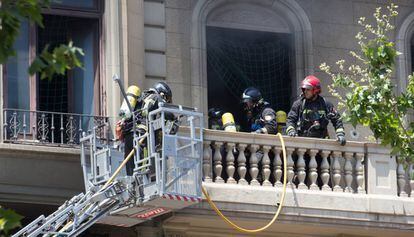 Bomberos extinguiendo el fuego del edificio.