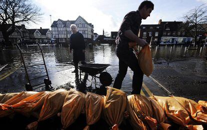Dos ciudadanos forman una barrera en una calle inundada de Datchet, Reino Unido