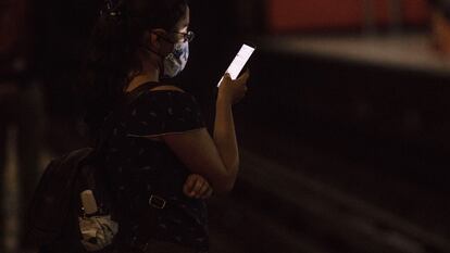 Una mujer usa su teléfono móvil mientras espera la llegada del Metro en Ciudad de México.