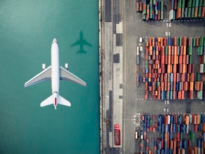 Airplane flying over container port