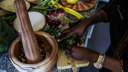 Mayra Gastro prepara una receta en su cocina haciendo un majado en el mortero, instrumento imprescindible en las cocinas africanas.