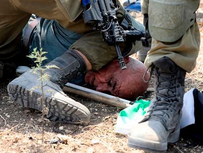 Un militar israelí presiona con su rodilla el cuelo del palestino Jairi Hanun, detenido el martes de Shufa (Cisjordania).