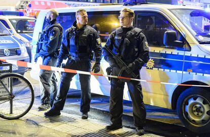 Tres agentes de policía aseguran la zona frente a la estación principal de ferrocarril de Dusseldorf (Alemania).