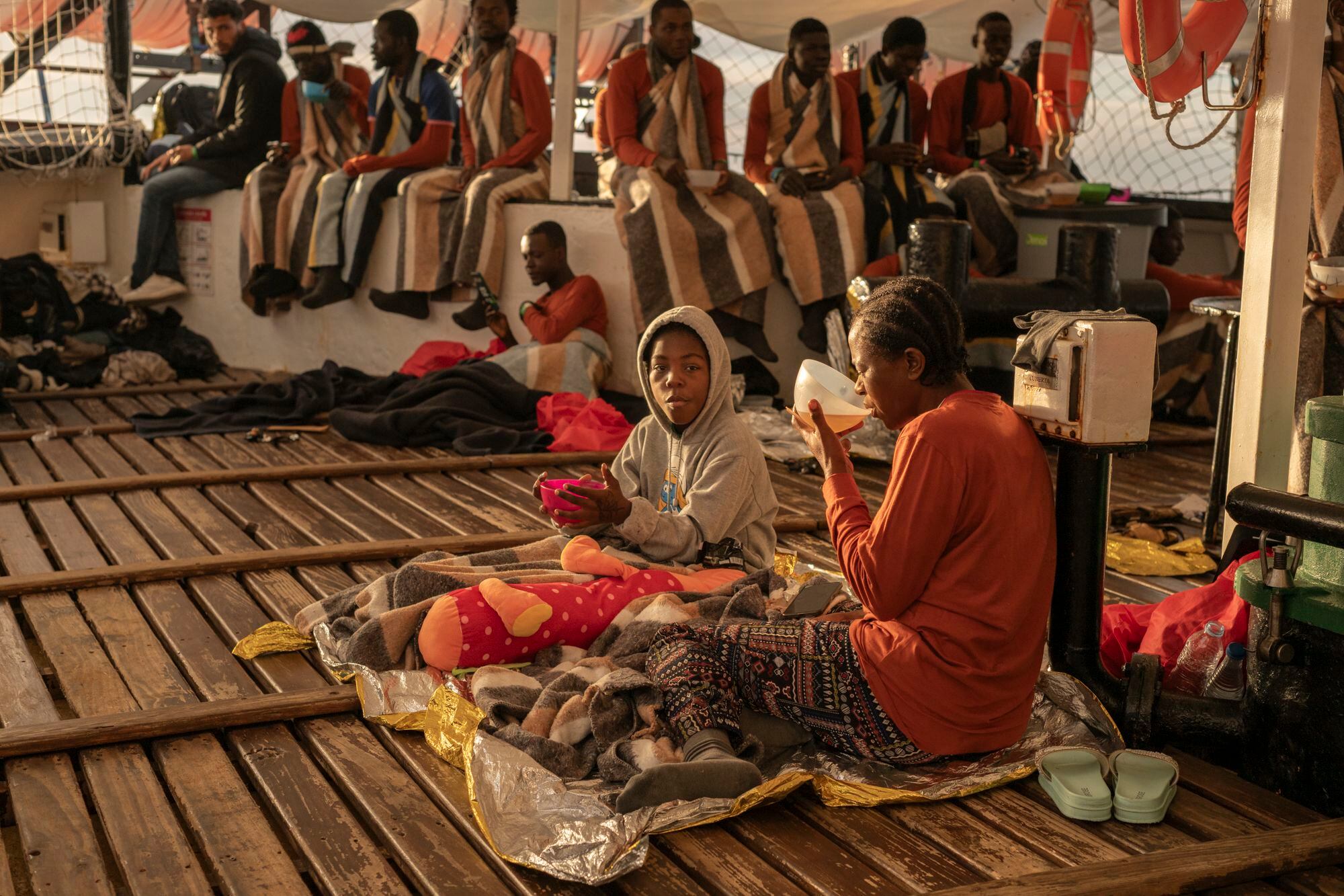 Davilla, una niña de Camerún que iba en la embarcación a punto de zozobrar junto con otras 53 personas, desayuna en la cubierta del Open Arms al lado de la mujer que viaja con ella. Según esta, Davilla fue abandonada por sus padres. La pequeña se ha ganado el corazón de todas las personas que componen la misión 107 de Open Arms.