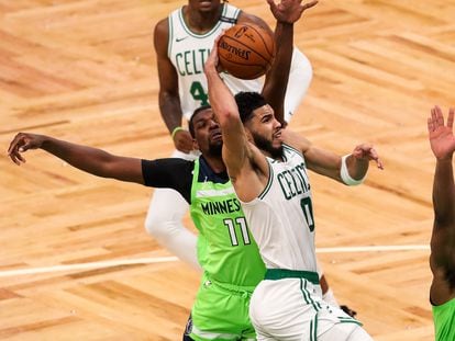 Jayson Tatum se dispone a anotar entre dos jugadores en el Celtics-Timberwolves.