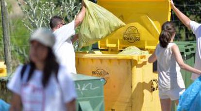 Voluntarios tiran bolsas de basura extraída en la batida de la Laguna del Campillo (Madrid).