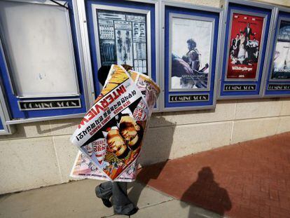 Un treballador retira els cartells de 'La entrevista' d'un cinema d'Atlanta.